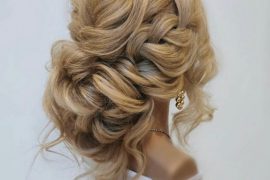 Chunky loose braided bun bridal hairstyle with soft messy texture and volume