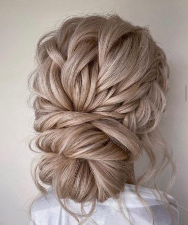 Subtle braided low bun with soft woven texture – minimal elegant bridal hairstyle