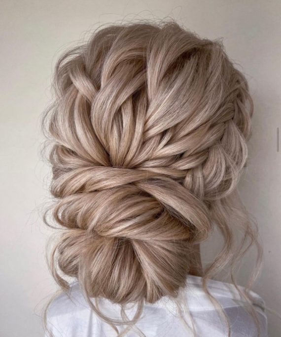 Subtle braided low bun with soft woven texture – minimal elegant bridal hairstyle