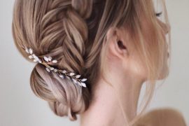 fStunning braided bun bridal hairstyle with side braid and floral hairpiece