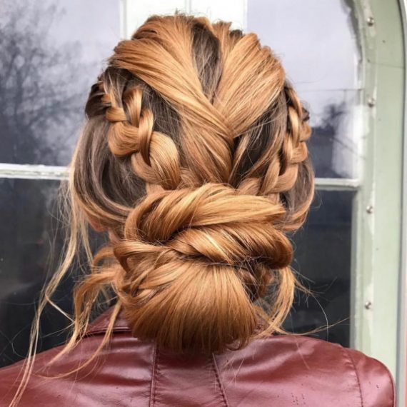 Bold edgy braided low bun hairstyle with twist details and volume for brides
