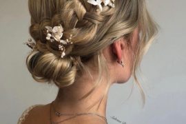 Crown braided low bun with butterfly pins – romantic bridal hairstyle with soft waves