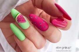 Almond-shaped nails with watermelon-inspired pink and green polish and seed nail art