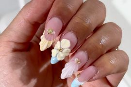 Almond nails with pink base, 3D shells and flower details, pastel blue tips, and gold starfish charms