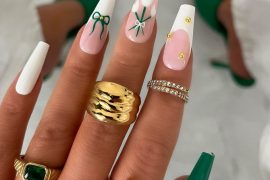 Long coffin nails with white and nude pink base, tulip and bow art, and gold stud embellishments