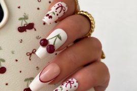 Long square nails with white base, 3D cherry accents, and red hand-painted bows and dots