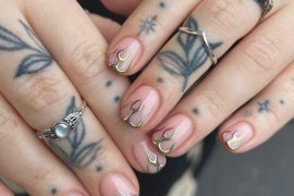 Short nude nails with iridescent chrome flame tips in gold and green hues