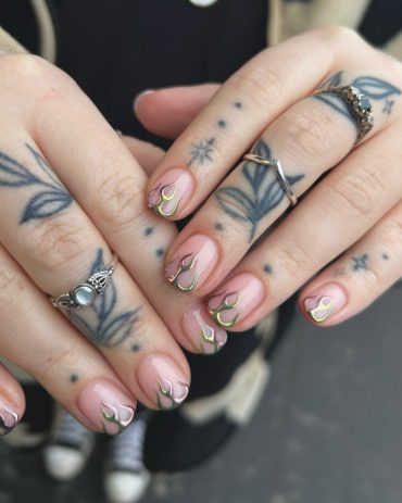 Short nude nails with iridescent chrome flame tips in gold and green hues
