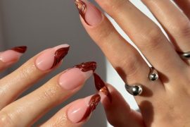 Almond-shaped nails with nude base and metallic copper swirl French tips, perfect for fall