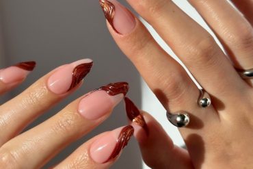 Almond-shaped nails with nude base and metallic copper swirl French tips, perfect for fall