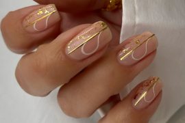 Short nude nails with gold foil, minimal white line art, and glossy finish