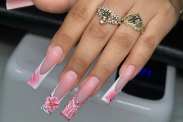Long coffin nails in soft pink tones with mismatched 3D art, including flowers, plaid patterns, zebra print, and pearl embellishments.