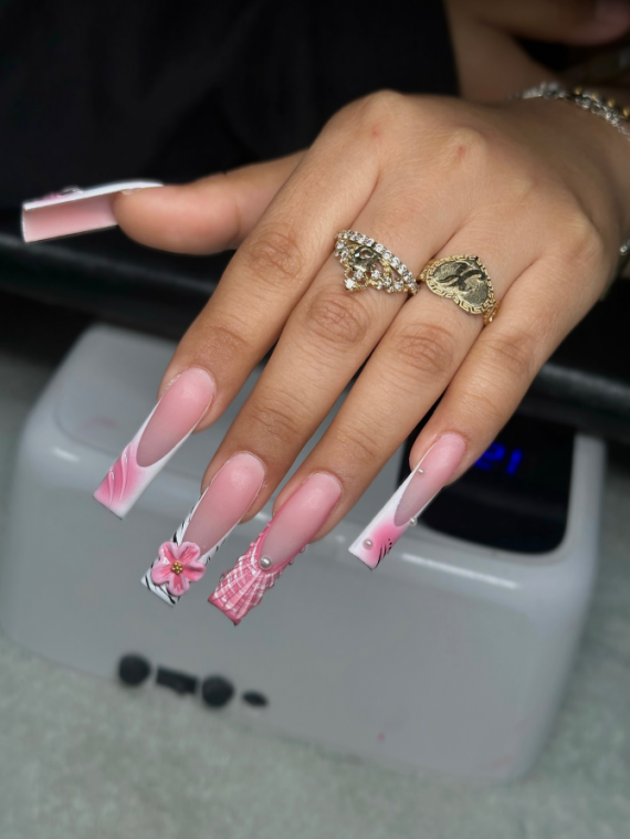 Long coffin nails in soft pink tones with mismatched 3D art, including flowers, plaid patterns, zebra print, and pearl embellishments.