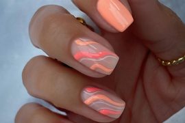 Short square nails with peach, coral, and pink swirl designs on nude base