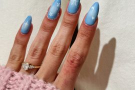 Almond-shaped soft blue aura nails with minimalist white bow, star, and floral line art designs