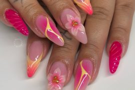 Stiletto-shaped summer nails in hot pink with 3D flower art, yellow aura waves, and gradient French tips