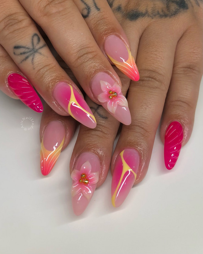Stiletto-shaped summer nails in hot pink with 3D flower art, yellow aura waves, and gradient French tips