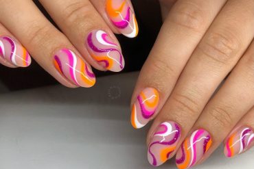 Almond-shaped nails with pink, orange, and yellow swirls inspired by summer sorbet
