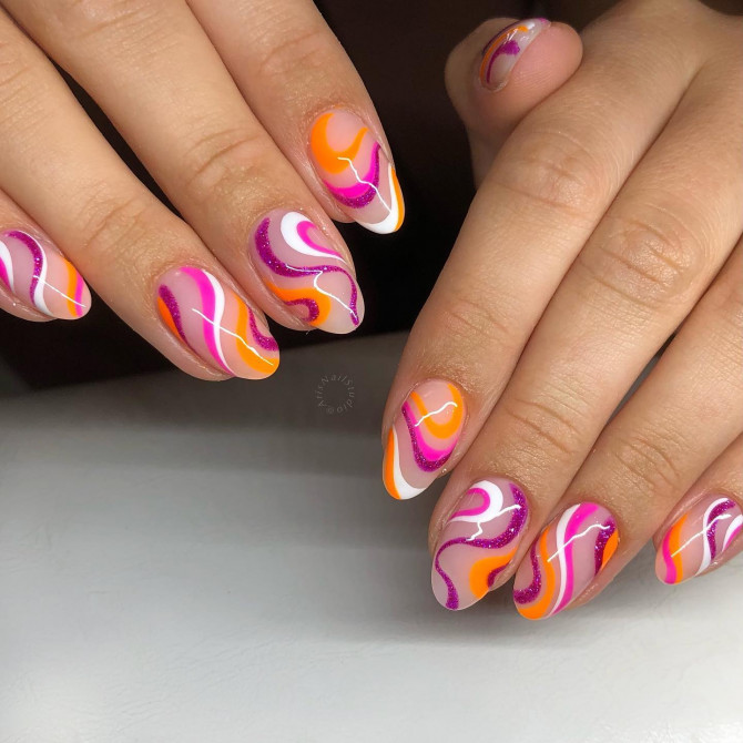 Almond-shaped nails with pink, orange, and yellow swirls inspired by summer sorbet