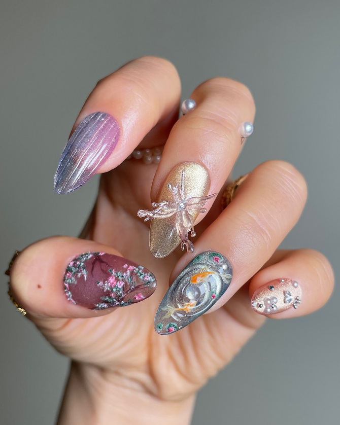 Almond-shaped nails with velvet and shimmer finishes, featuring cherry blossoms, koi fish, a 3D dragonfly charm, and glitter accents.