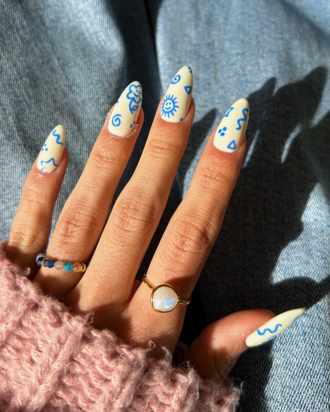 Blue Doodle on White Almond Nails for a Youthful Twist