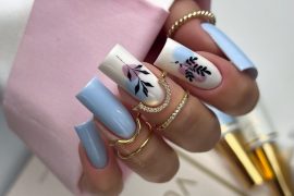 Coffin-shaped blue nails with abstract floral design on white accent nails