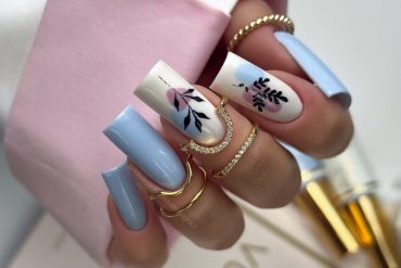 Coffin-shaped blue nails with abstract floral design on white accent nails