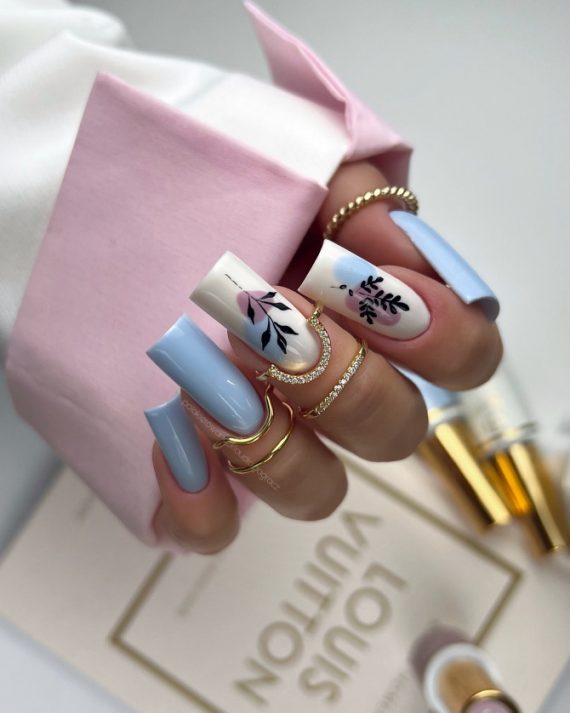 Coffin-shaped blue nails with abstract floral design on white accent nails