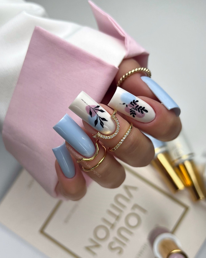 Coffin-shaped blue nails with abstract floral design on white accent nails