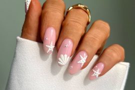 Glossy almond pink nails with 3D white starfish, seashell, and pearl accents