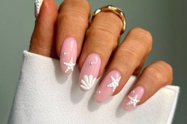 Glossy almond pink nails with 3D white starfish, seashell, and pearl accents