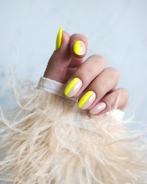 half neon yellow and half nude nails in a glossy oval-round shape