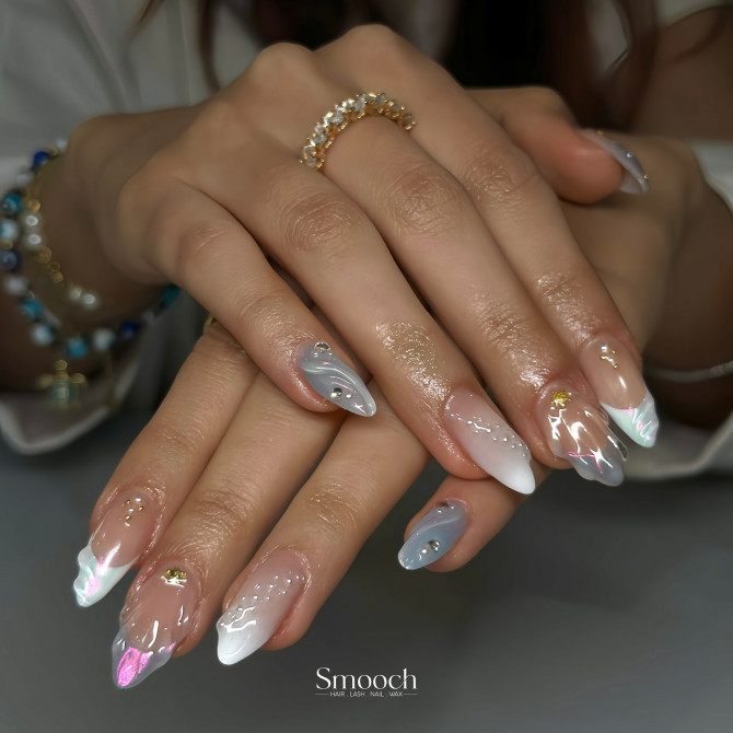  Almond nails with chrome swirls, pearlescent tips, nude base, and gold foil embellishments
