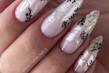 Almond nude nails with black and silver leaf nail art over a glossy pink base