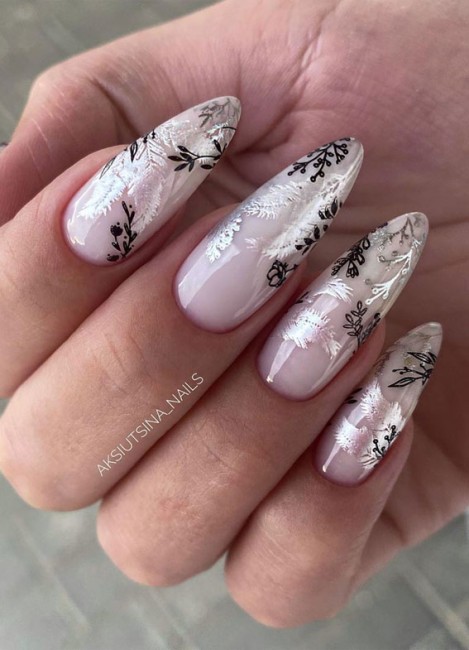 Almond nude nails with black and silver leaf nail art over a glossy pink base