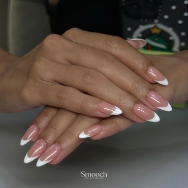 Long almond-shaped nails with nude pink base and clean white French tips