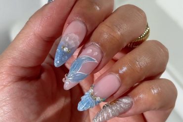 Long stiletto nails with chrome silver, blue jelly tips, and seashell textures on a pink-nude base
