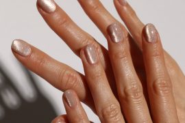 hort oval nails in nude polish with champagne shimmer and glossy finish
