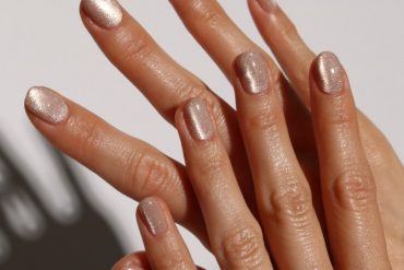 hort oval nails in nude polish with champagne shimmer and glossy finish. Short oval nude nails with champagne shimmer glow, perfect for summer