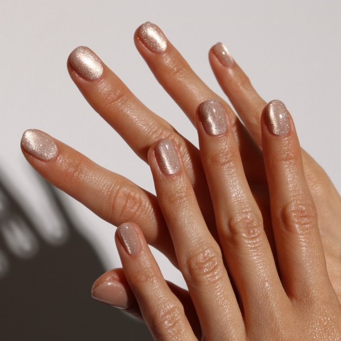 hort oval nails in nude polish with champagne shimmer and glossy finish