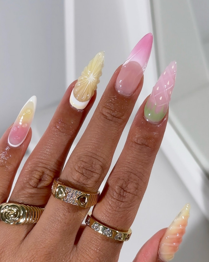 Long stiletto nails with pink, yellow, and green pastel gradients and 3D fruit-inspired textures