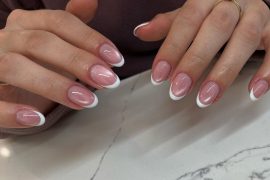 Short almond nails with mauve cat-eye shimmer base and classic white French tips