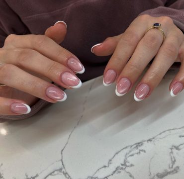 Short almond nails with mauve cat-eye shimmer base and classic white French tips