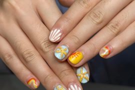 Short round nails with tropical swirl designs, sun motifs, white shell stripes, and 3D starfish accents