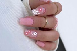 Coffin-shaped nails in soft pink with gold specks and white leaf designs