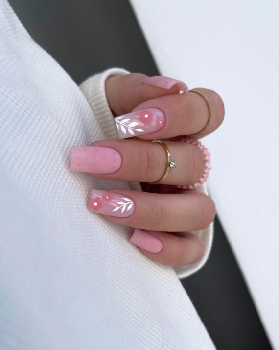 Coffin-shaped nails in soft pink with gold specks and white leaf designs