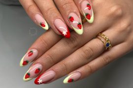 Almond-shaped nails with hand-painted strawberries, pastel French tips, and daisy details on a nude base