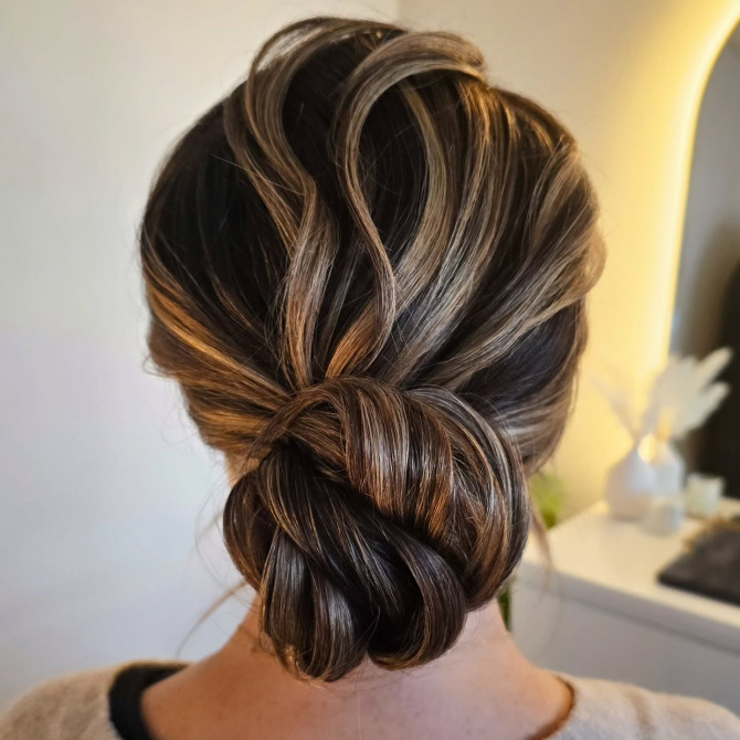 Twisted low bridal bun in brunette and caramel tones.