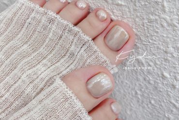 Minimalist beige pearl toenail design with soft shimmer and natural square shape