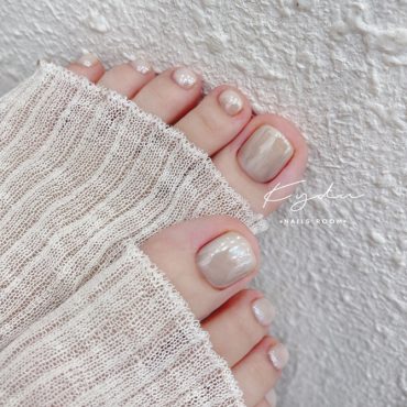 Minimalist beige pearl toenail design with soft shimmer and natural square shape